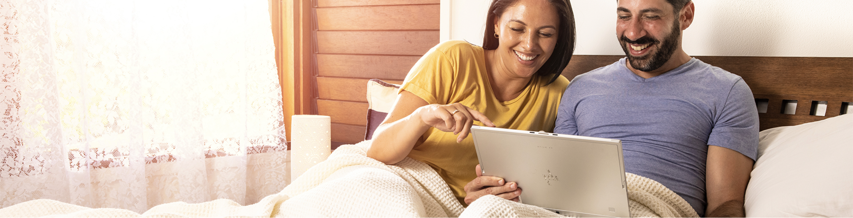 couple in bed with laptop